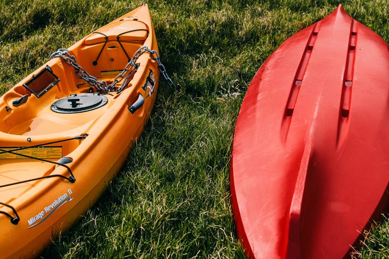 Red and Orange Kayak on Top of Grass