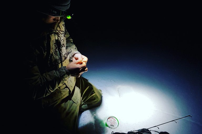 Fisherman Fixing Lure on Ice