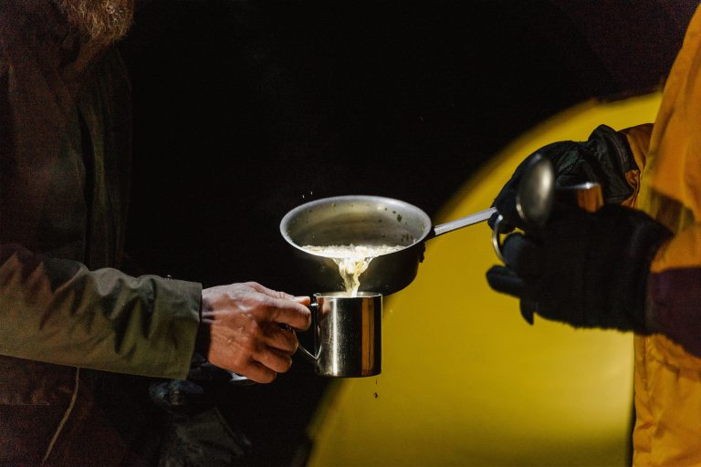 Fishermen Transfering Soup Into a Cup