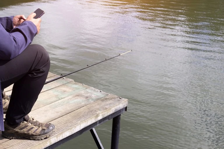 Man on a Dock Using a Smartphone