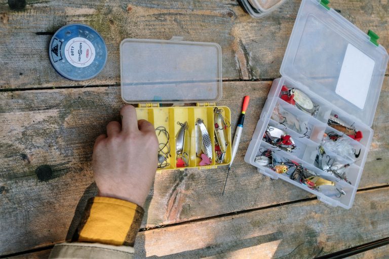 Fisherman Organizing Lures on a Wooden Table