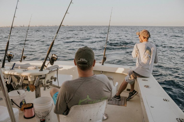 two people on a boat with fishing rods